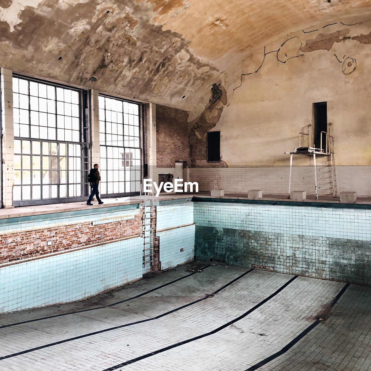 REAR VIEW OF MAN STANDING IN SWIMMING POOL