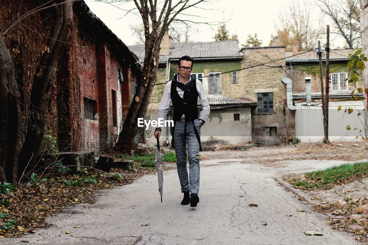 Full length of self-confident retro-styled man walking outdoors.