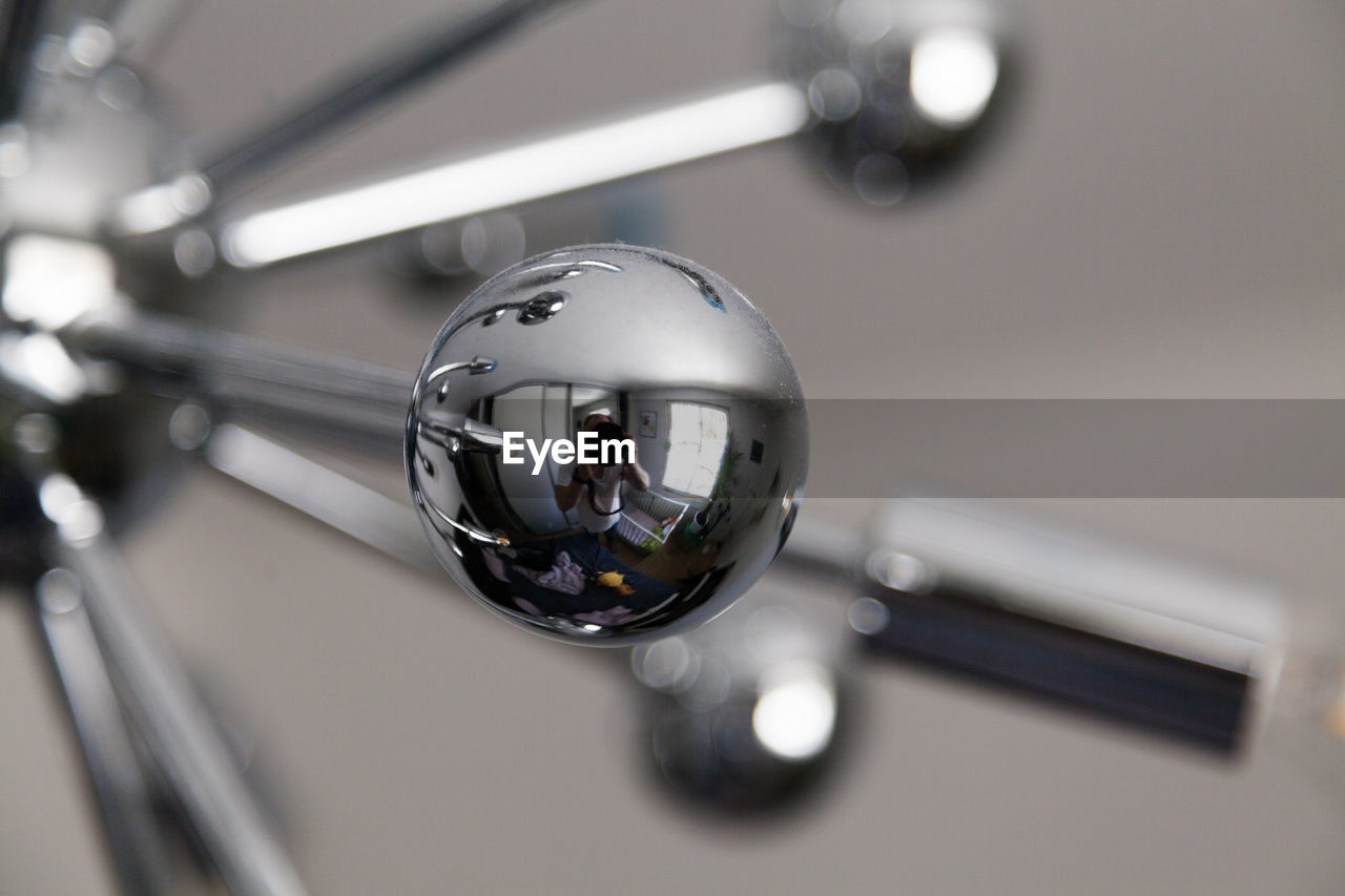 vehicle, silver, light, indoors, wheel, shiny, sphere, close-up, reflection, metal, no people