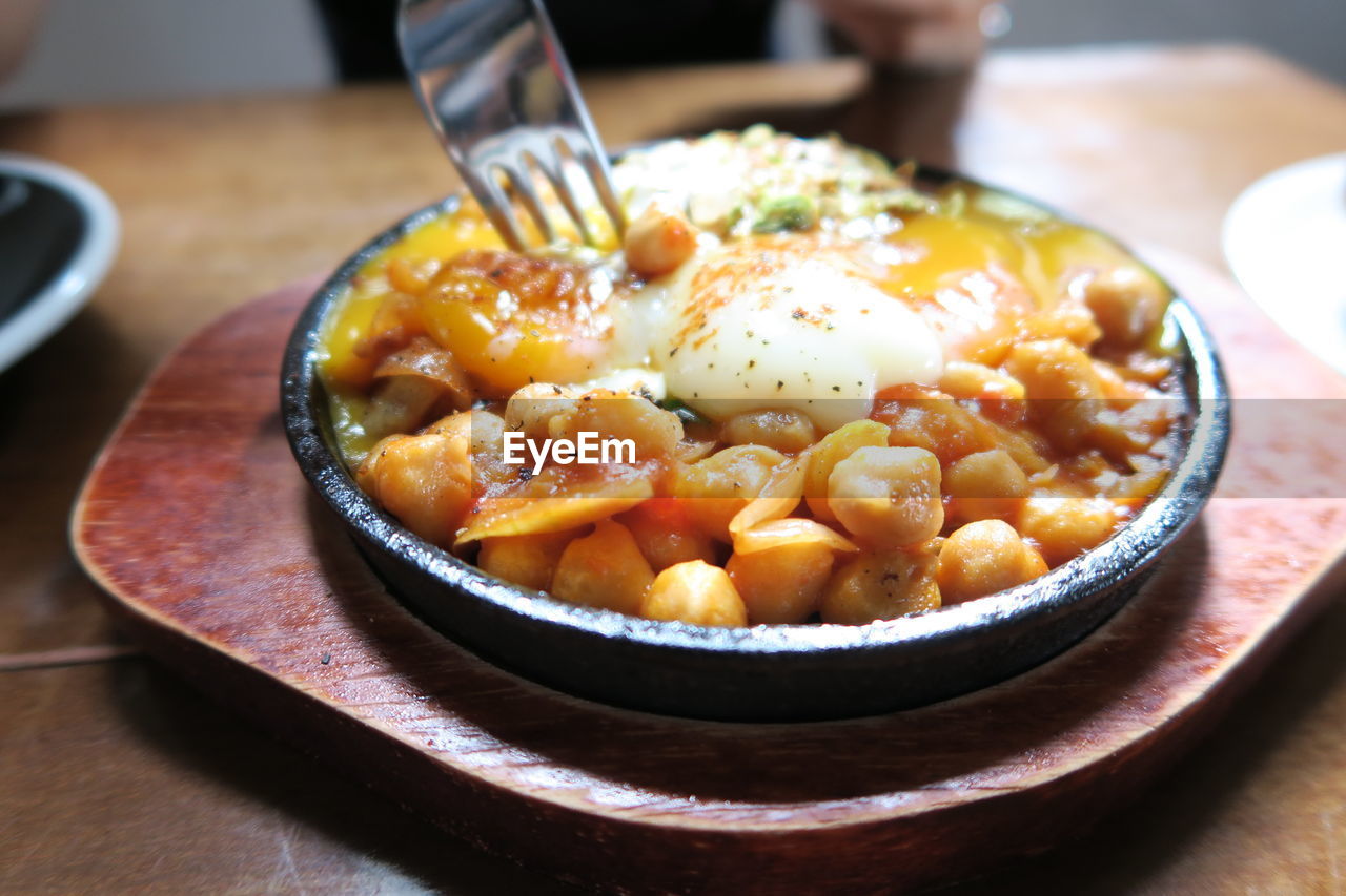 Close-up of chick-pea served with egg yolk on plate