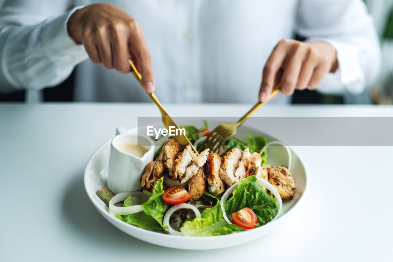 cropped hand of person preparing food in bowl on table