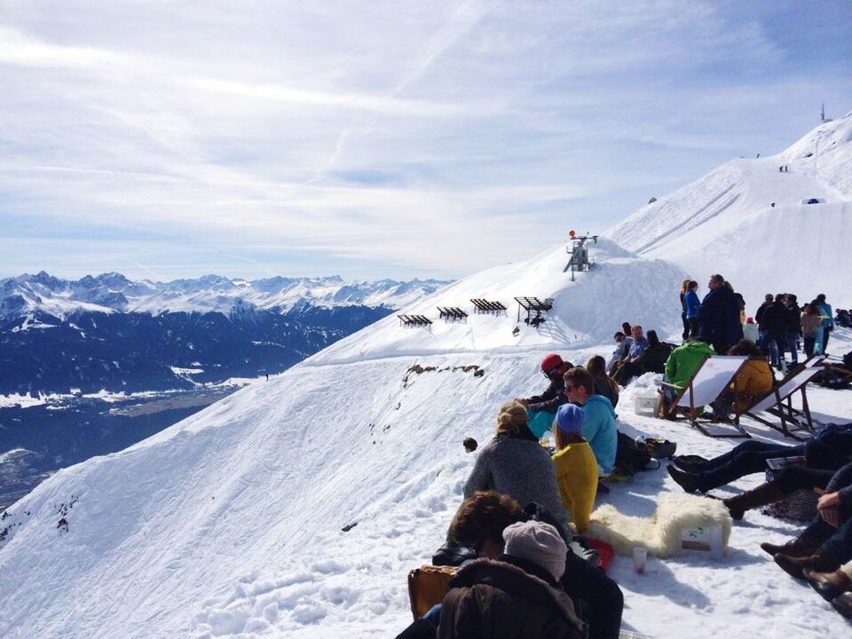 TOURISTS SKIING ON SNOW COVERED LANDSCAPE