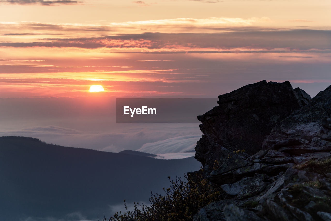 Scenic view of silhouette mountains against sky at sunset