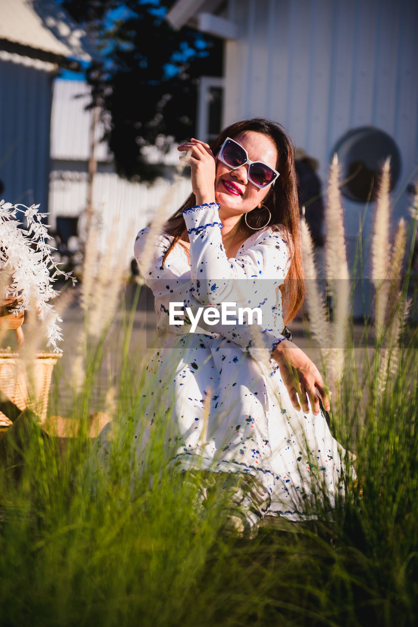 YOUNG WOMAN WEARING SUNGLASSES ON FIELD DURING RAINY SEASON