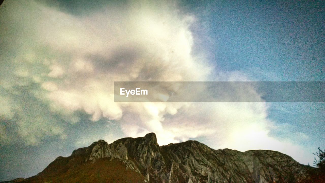 SCENIC VIEW OF MOUNTAINS AGAINST CLOUDY SKY