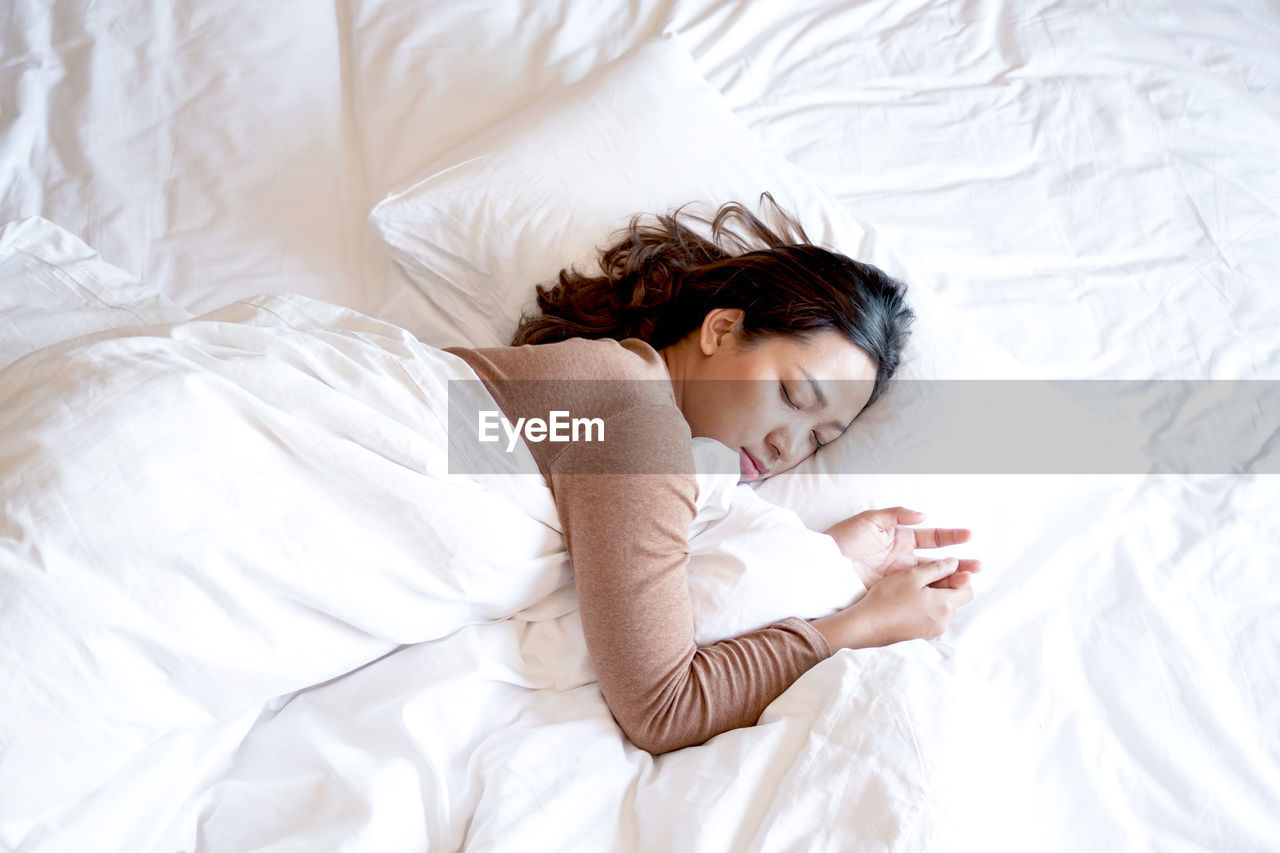 High angle view of baby sleeping on bed