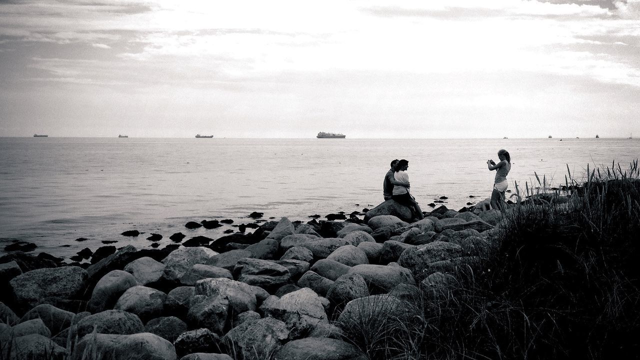 Woman photographing couple at beach