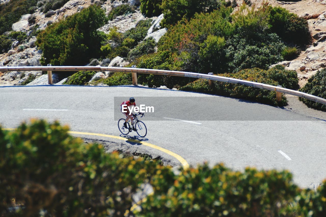 Male triathlete cyclist cycling on road