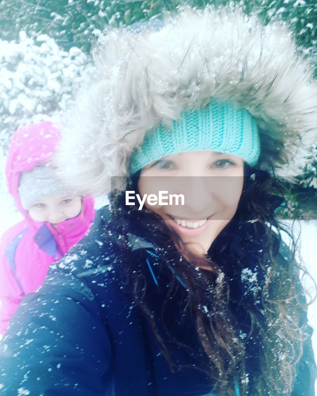 Portrait of smiling mother and daughter during winter