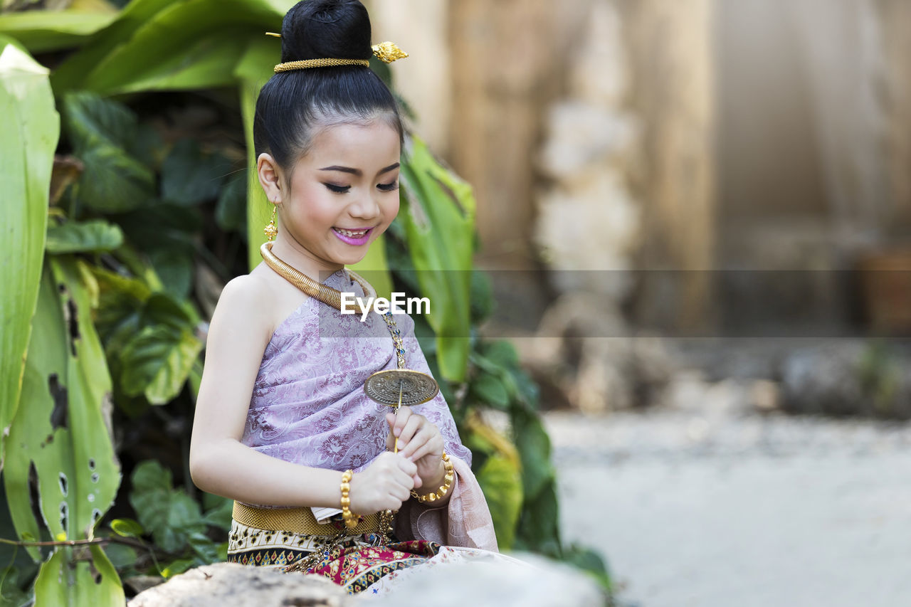 side view of young woman sitting on bench