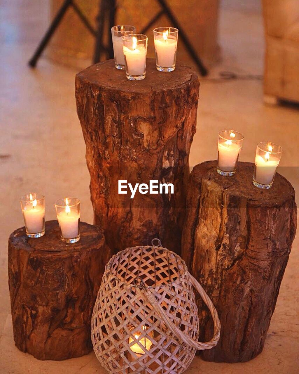 Close-up of illuminated candles on logs in room