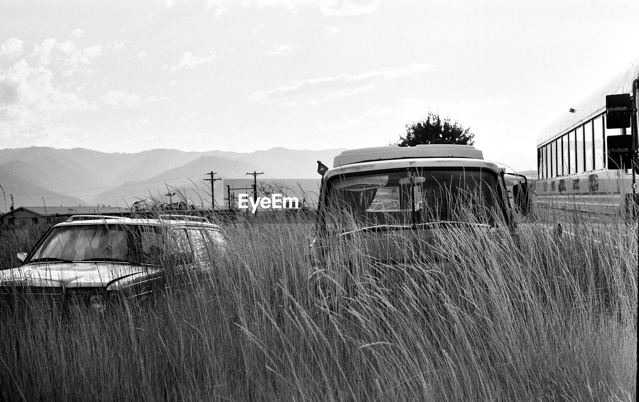 ABANDONED TRUCK ON FIELD AGAINST SKY