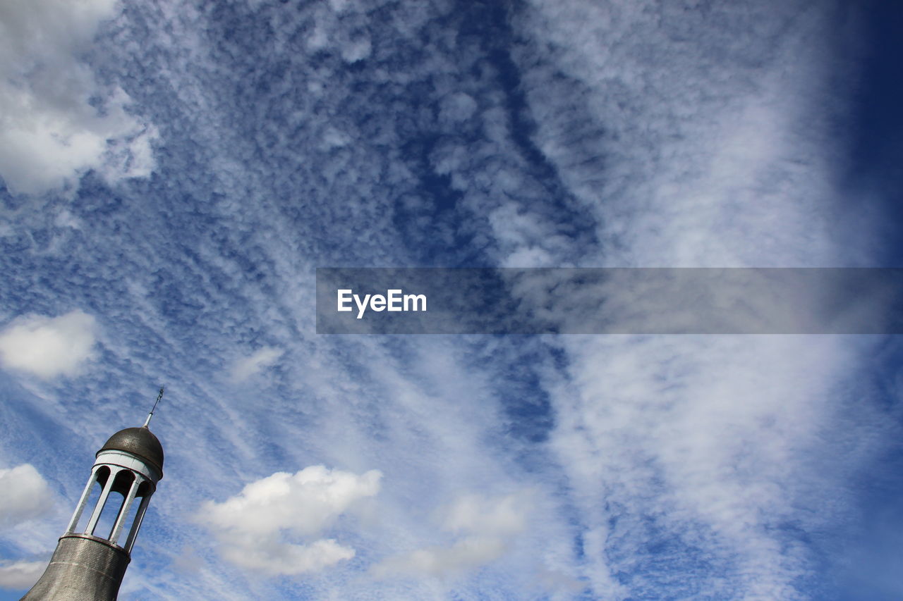 Low angle view of tower against cloudy sky