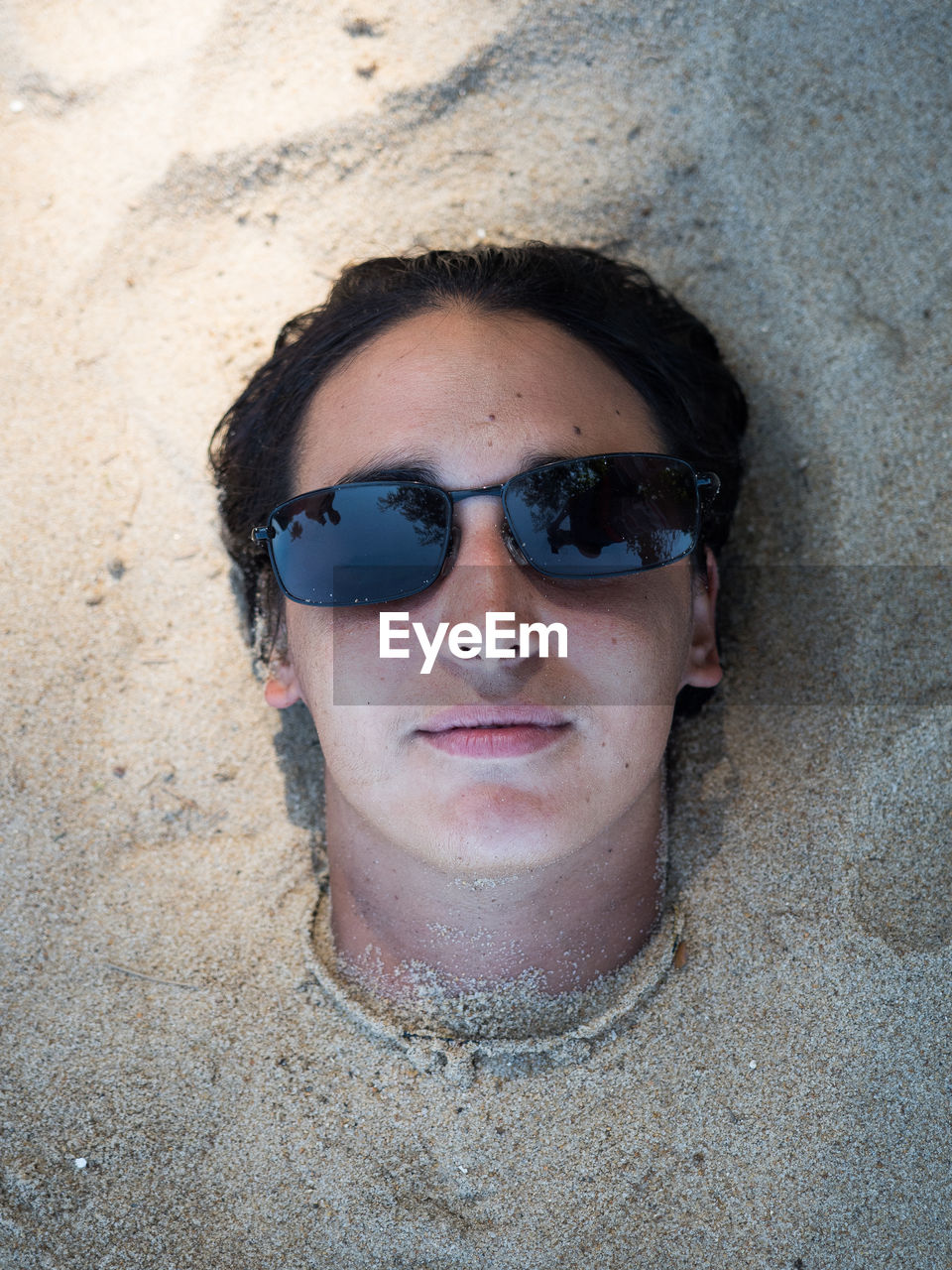 Portrait of woman buried in sand