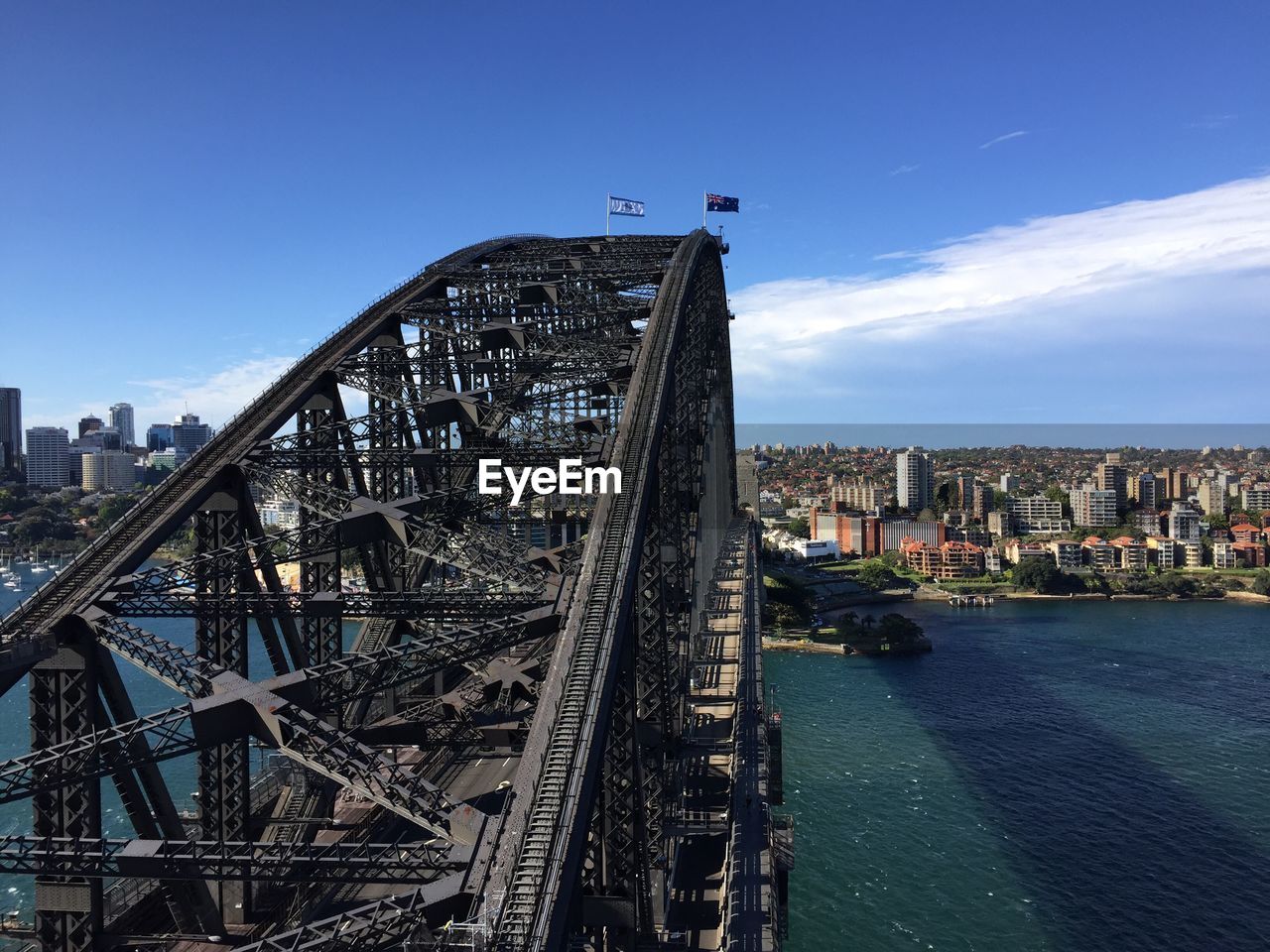 Sydney harbor bridge over parramatta river by cityscape against sky