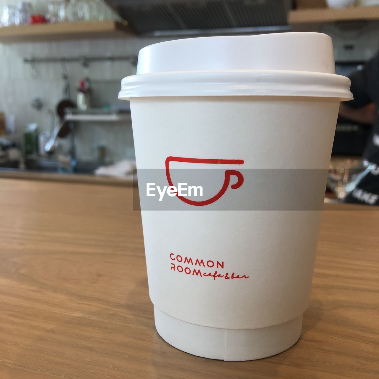 CLOSE-UP OF COFFEE CUP WITH TEXT ON TABLE