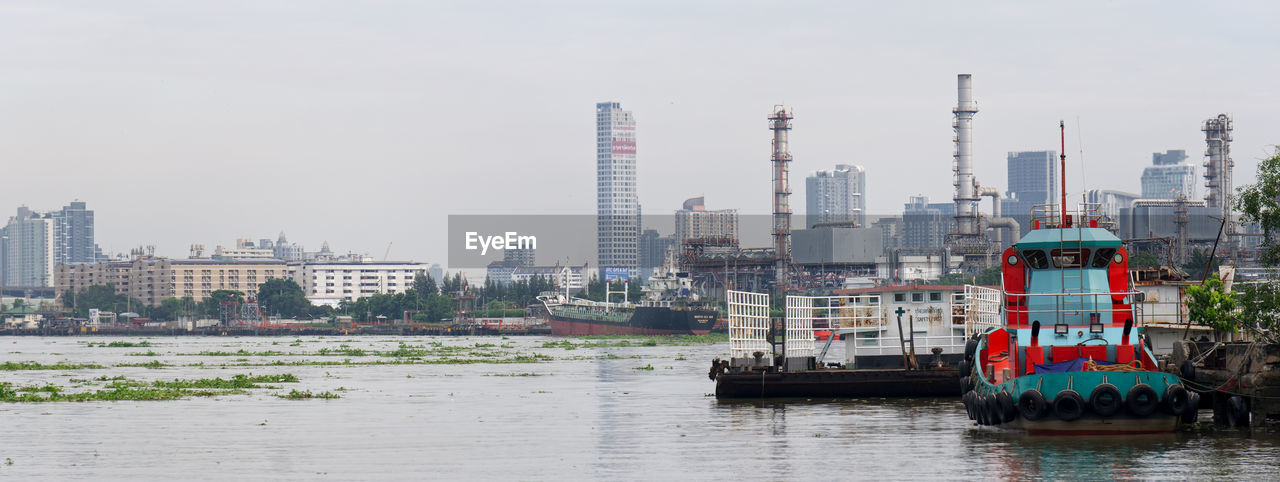 BUILDINGS BY RIVER AGAINST SKY