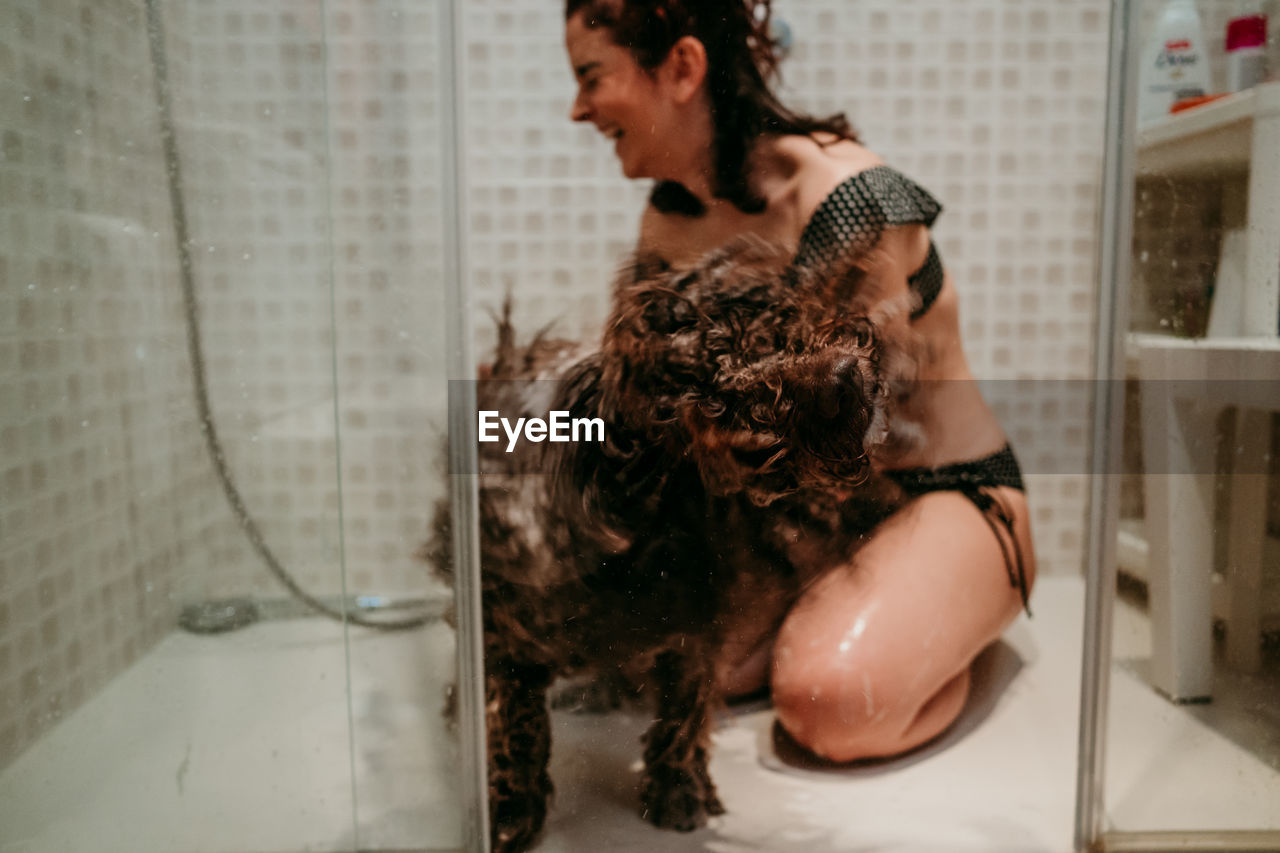 Young woman and dog in bathroom