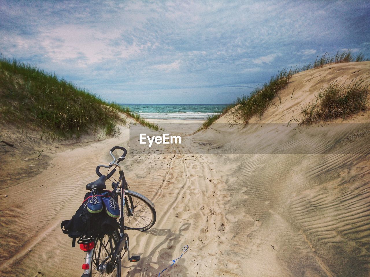 Bicycle parked on footpath at beach