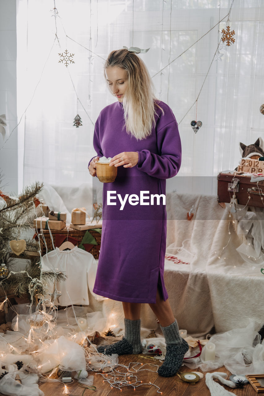 Full length of woman standing amidst christmas decoration