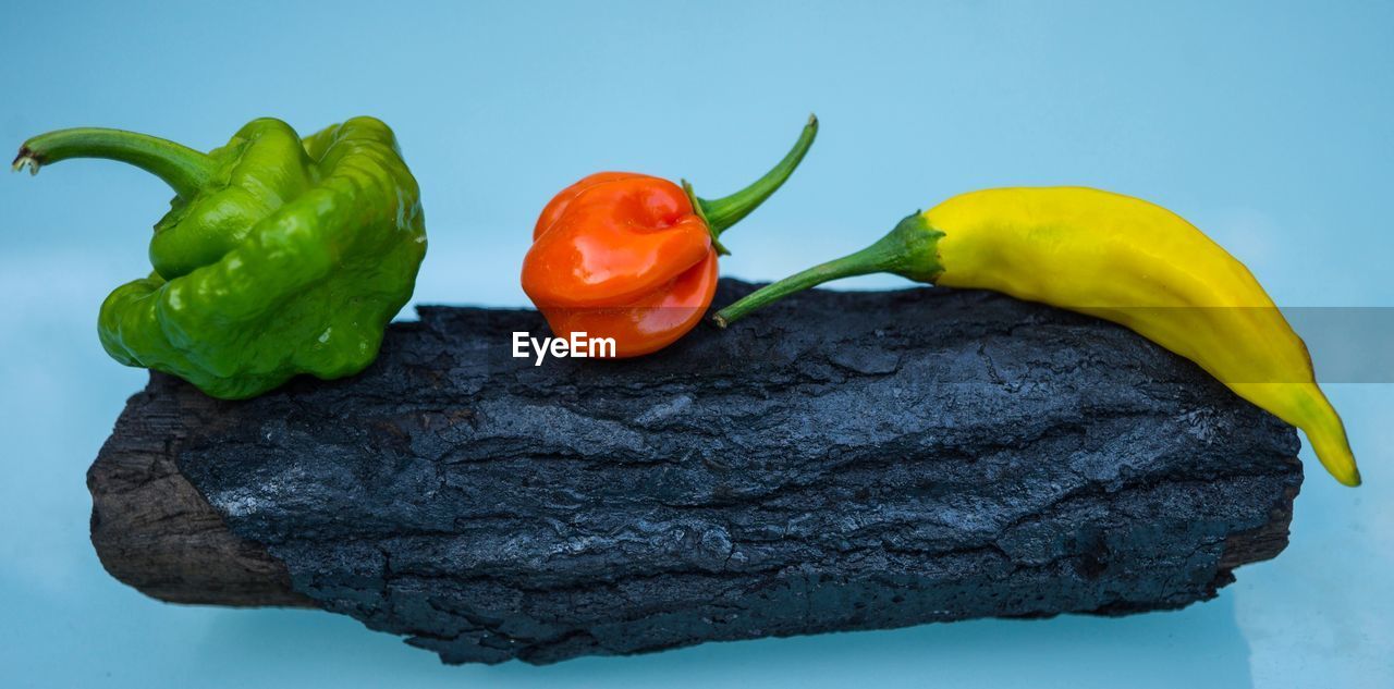 HIGH ANGLE VIEW OF RED BELL PEPPERS AND LEAVES