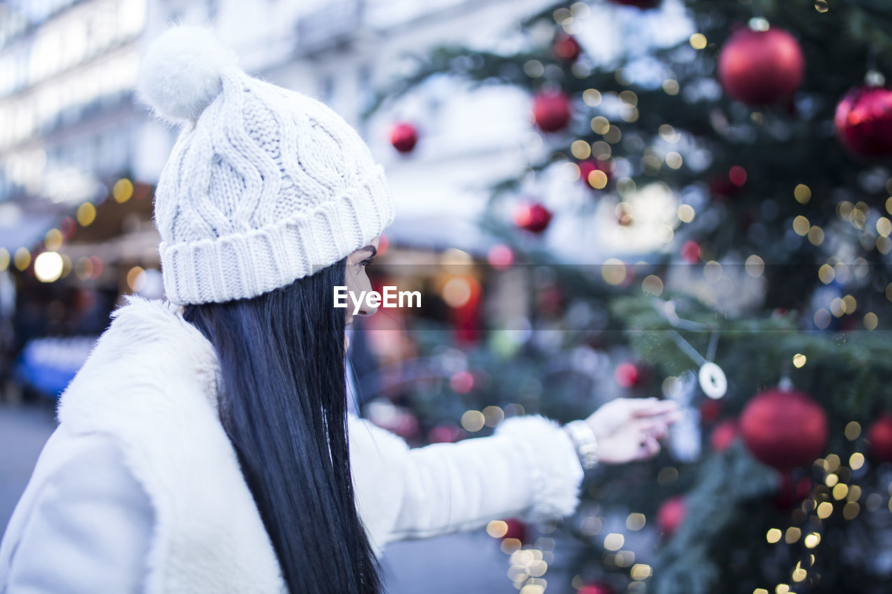 WOMAN WITH CHRISTMAS TREE IN CITY