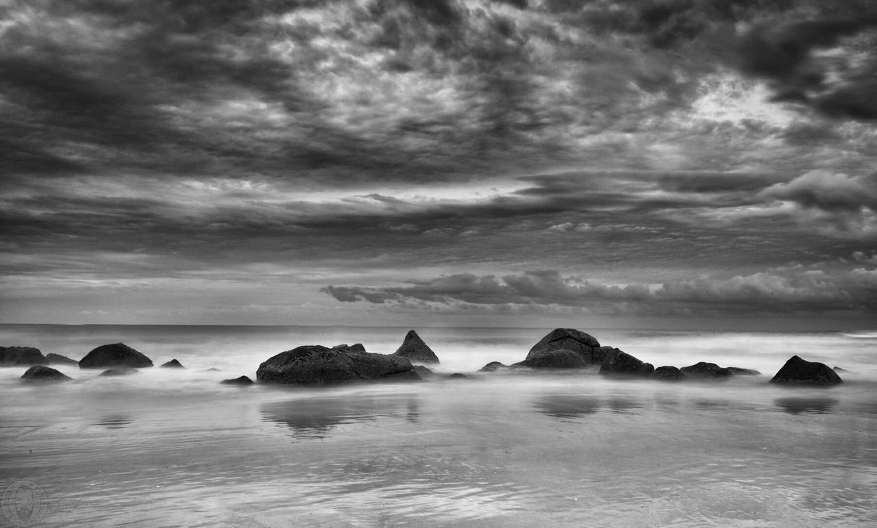 Scenic view of beach and sea against cloudy sky