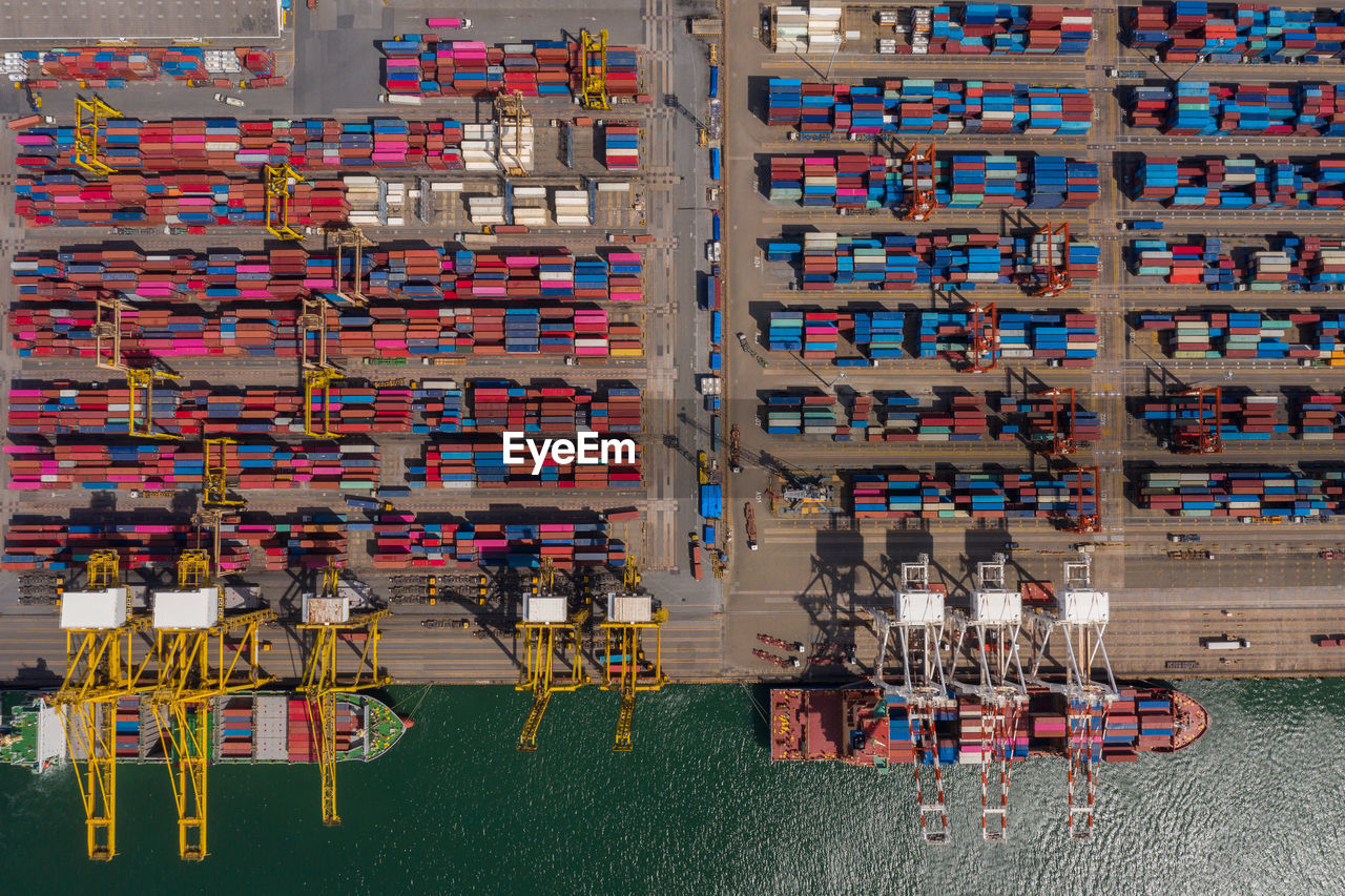 Container ship loading and unloading in sea port, aerial view of business logistic import and export 