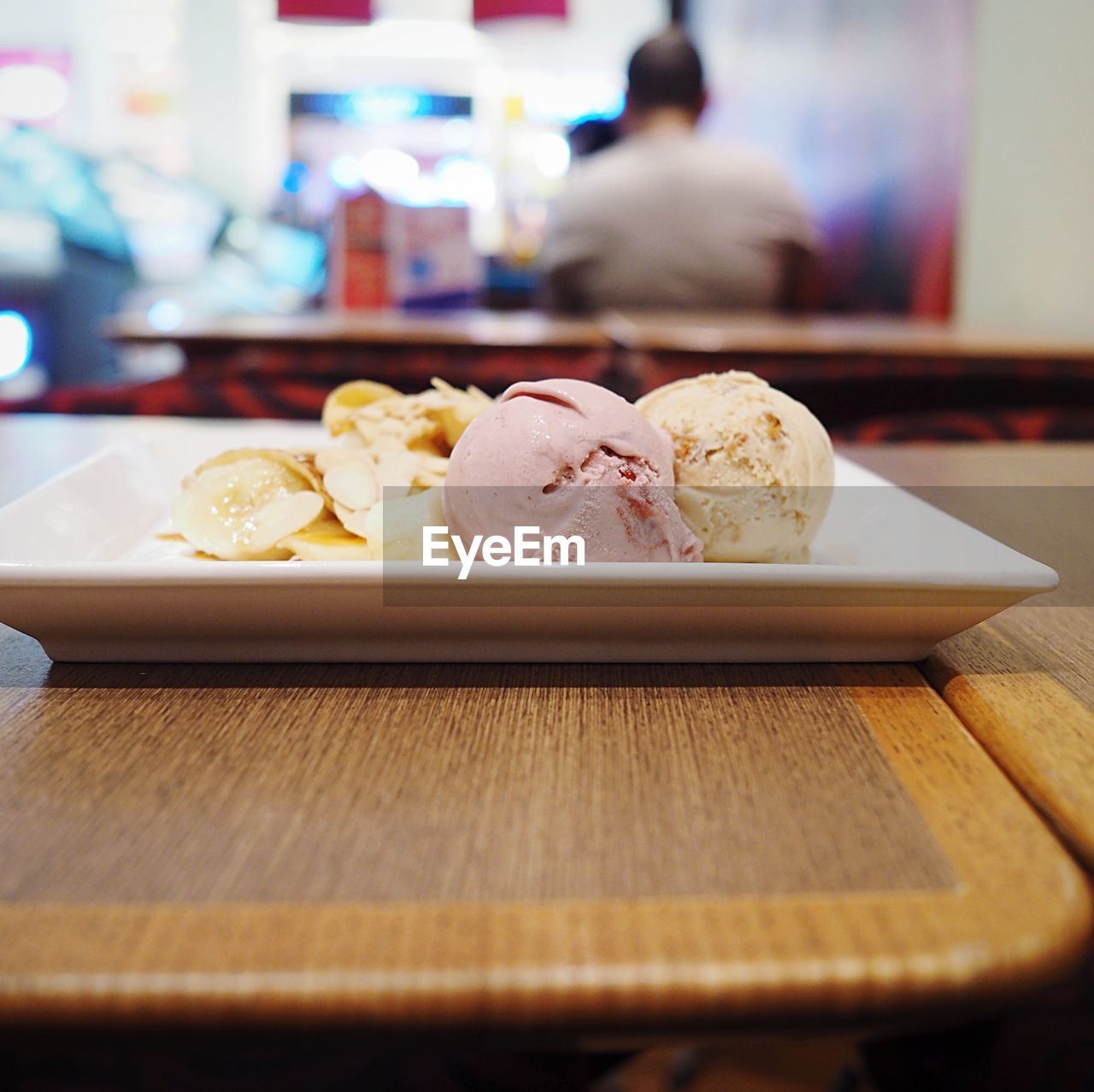 Close-up of ice creams with snack in plate on wooden table