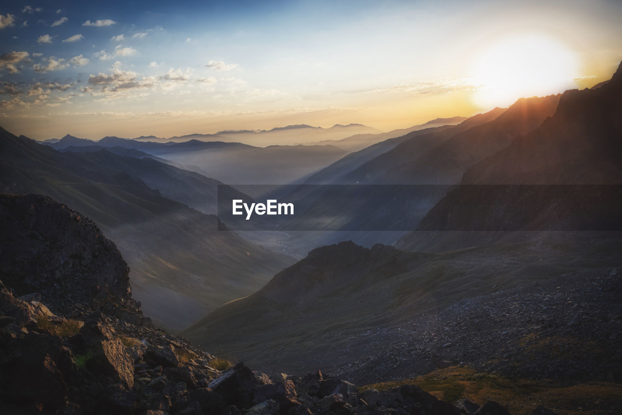 Scenic view of mountains against sky during sunrise.