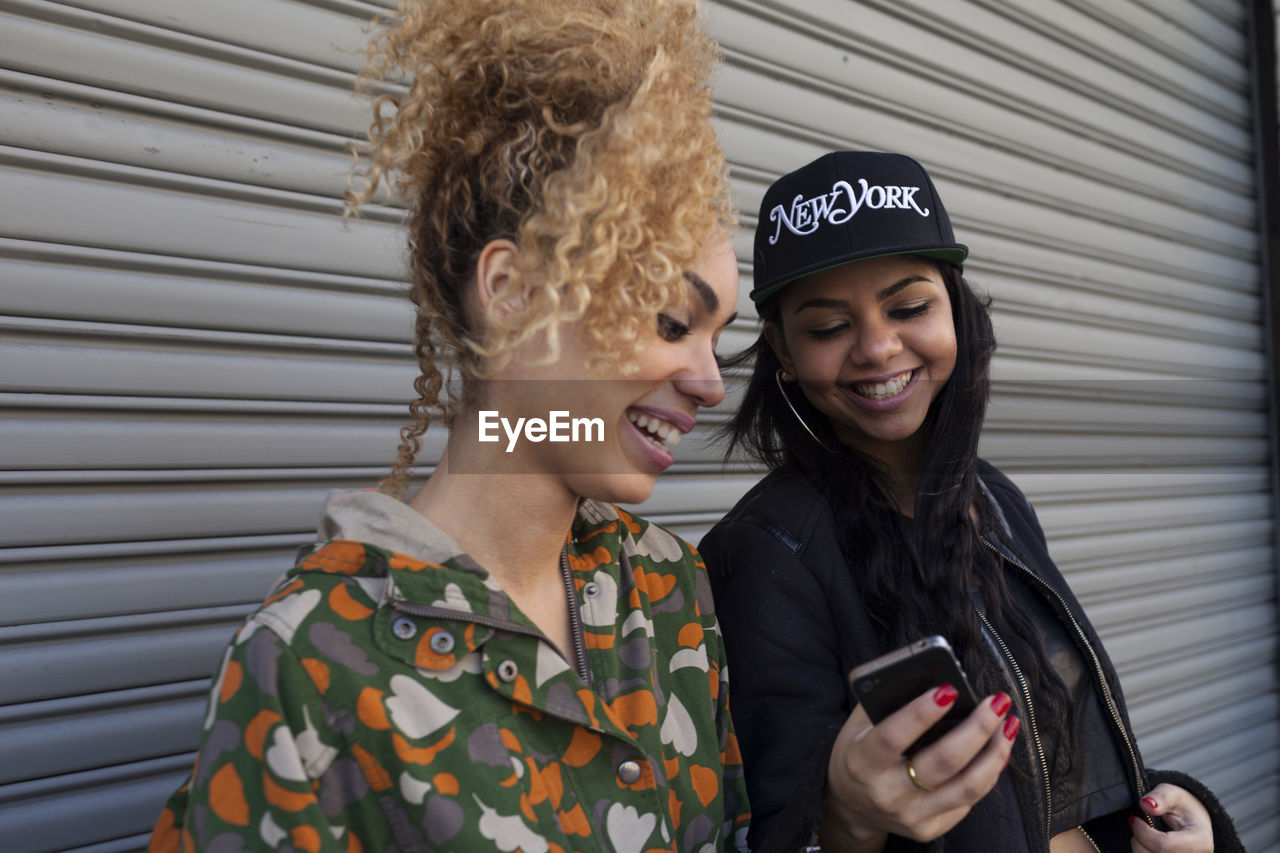 Smiling young women looking at a cell phone