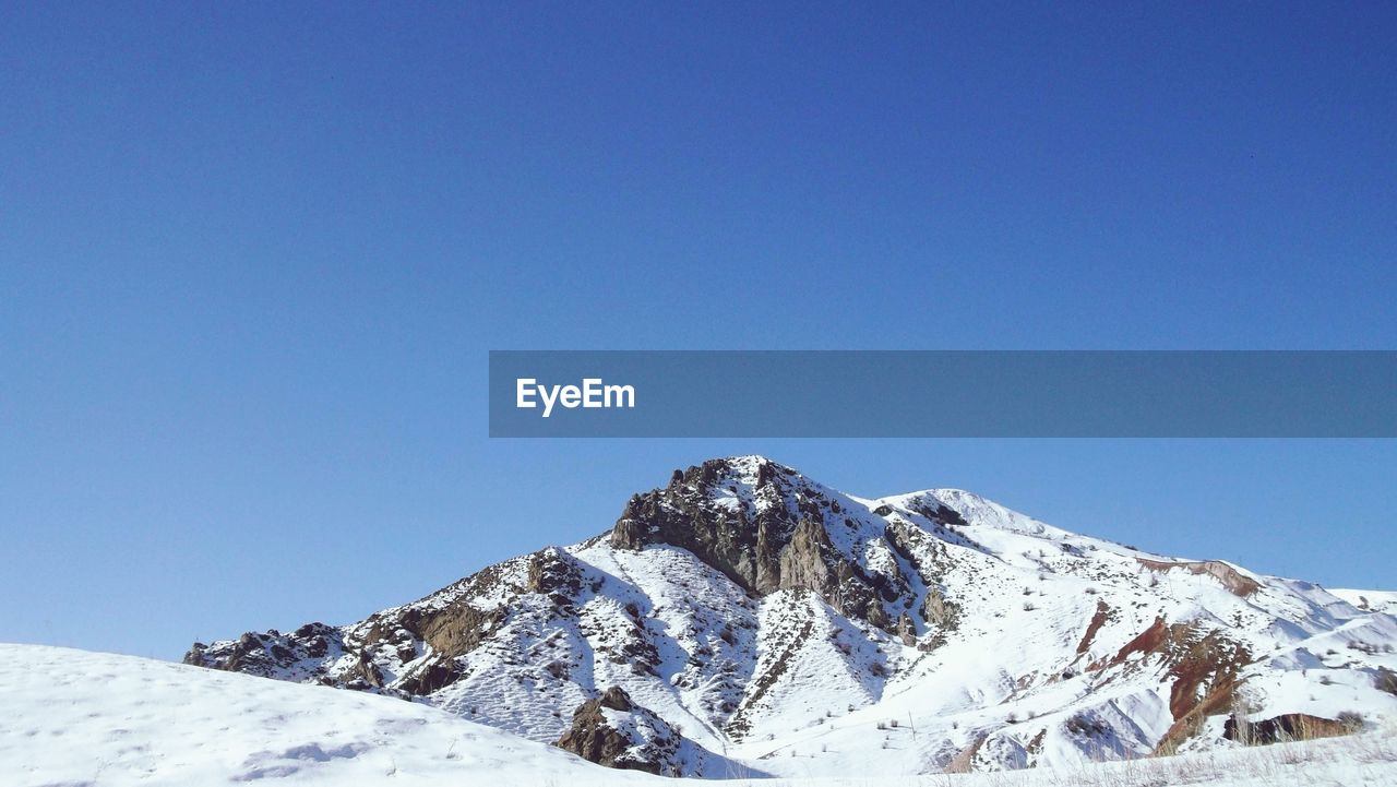 SNOWCAPPED MOUNTAIN AGAINST CLEAR BLUE SKY