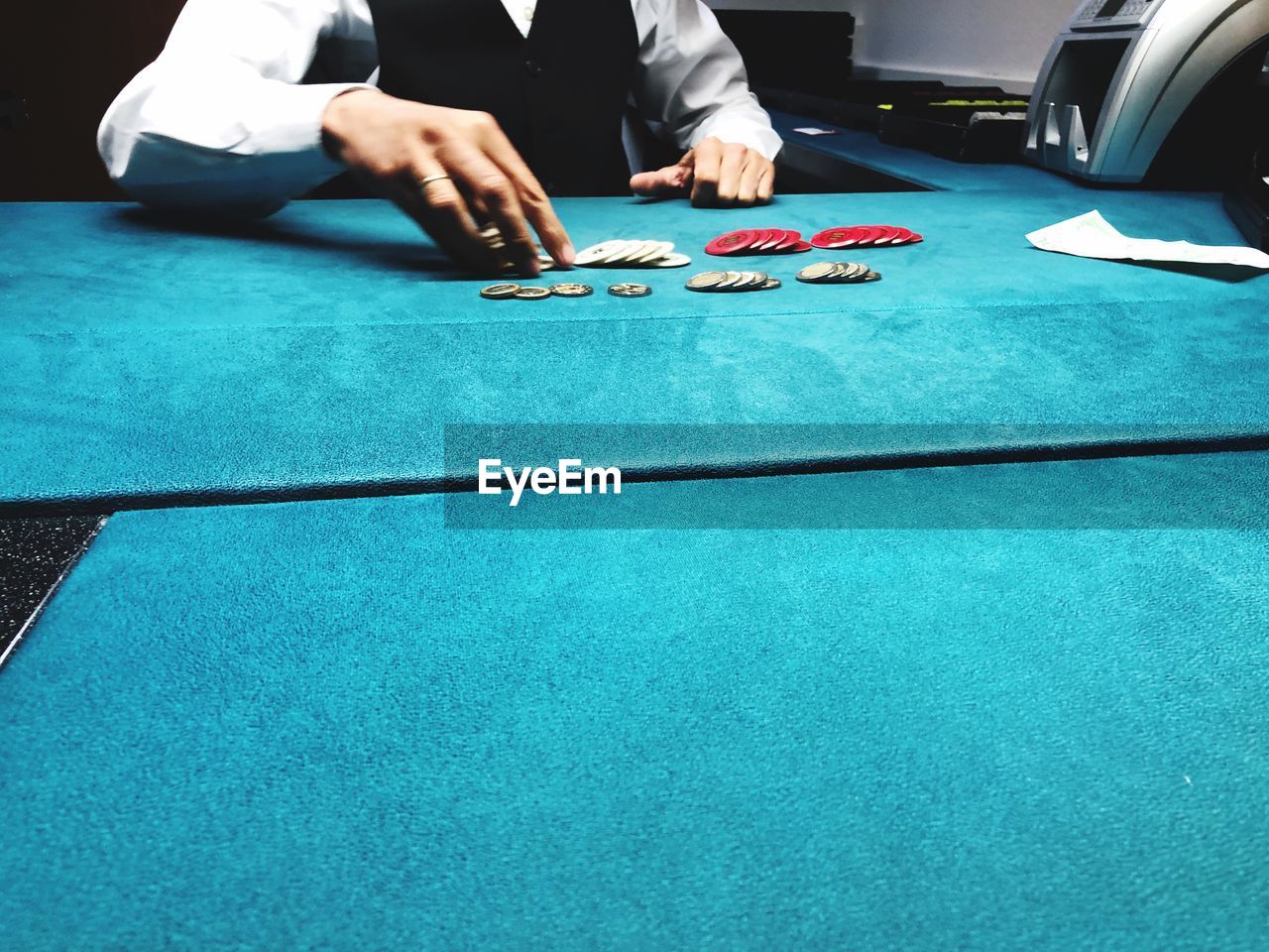 Midsection on man playing poker on table