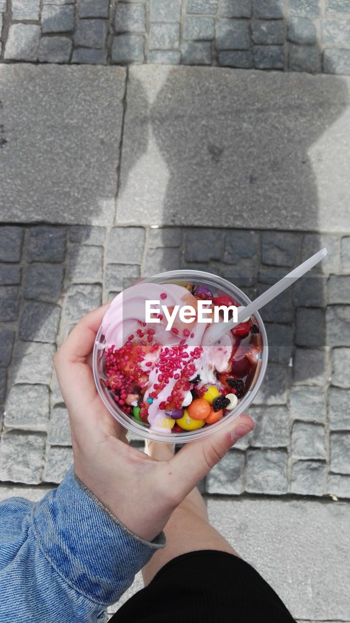 LOW SECTION OF WOMAN HOLDING ICE CREAM IN BOWL