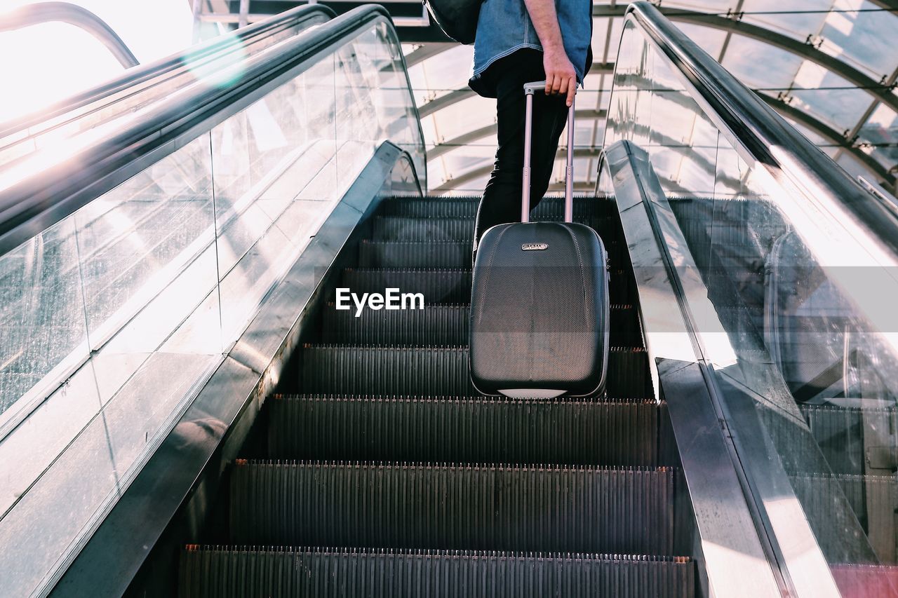 LOW SECTION OF PERSON ON ESCALATOR IN SUBWAY