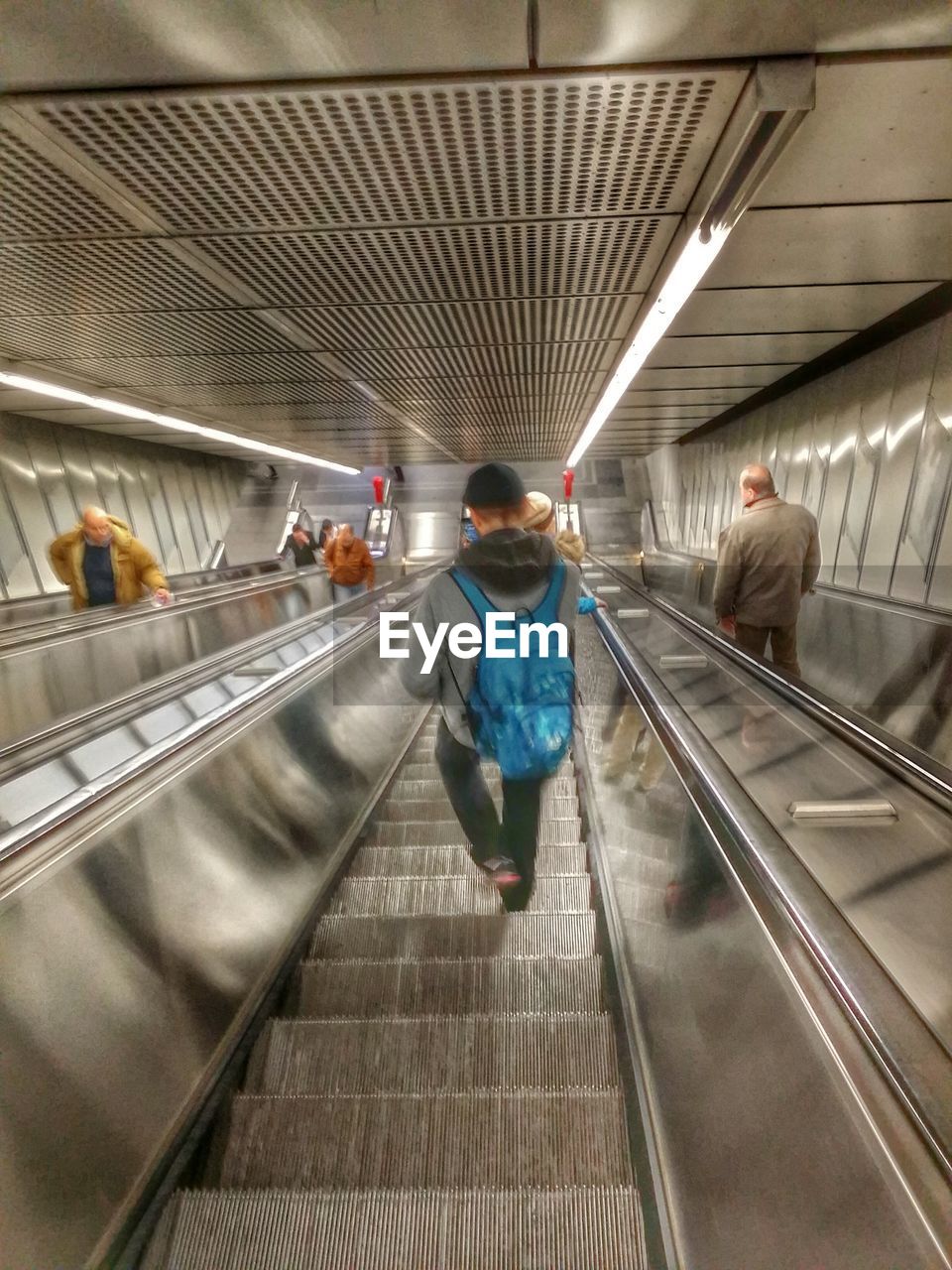 WOMAN STANDING ON ESCALATOR