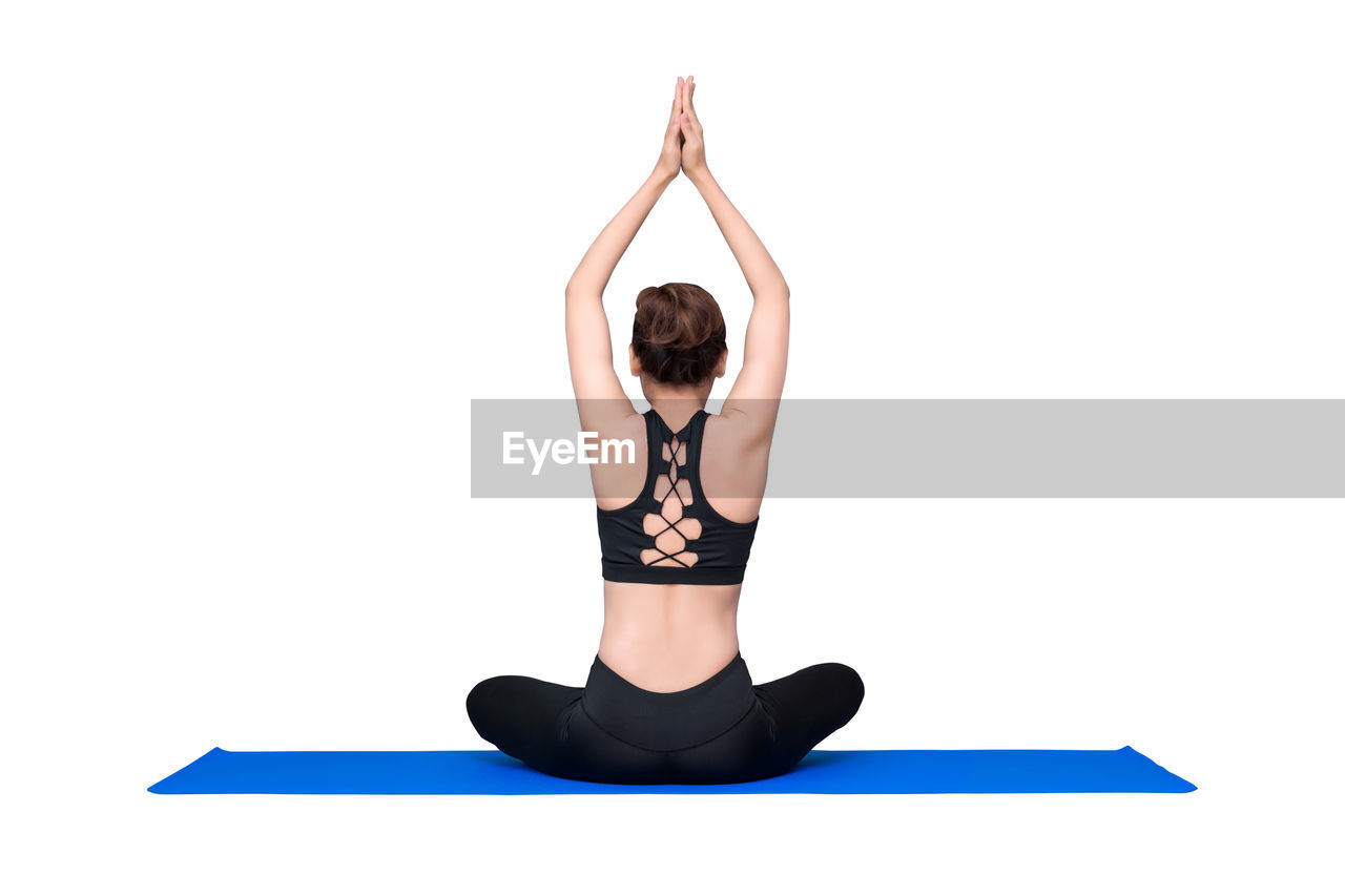 MIDSECTION OF WOMAN WITH HAT AGAINST WHITE BACKGROUND