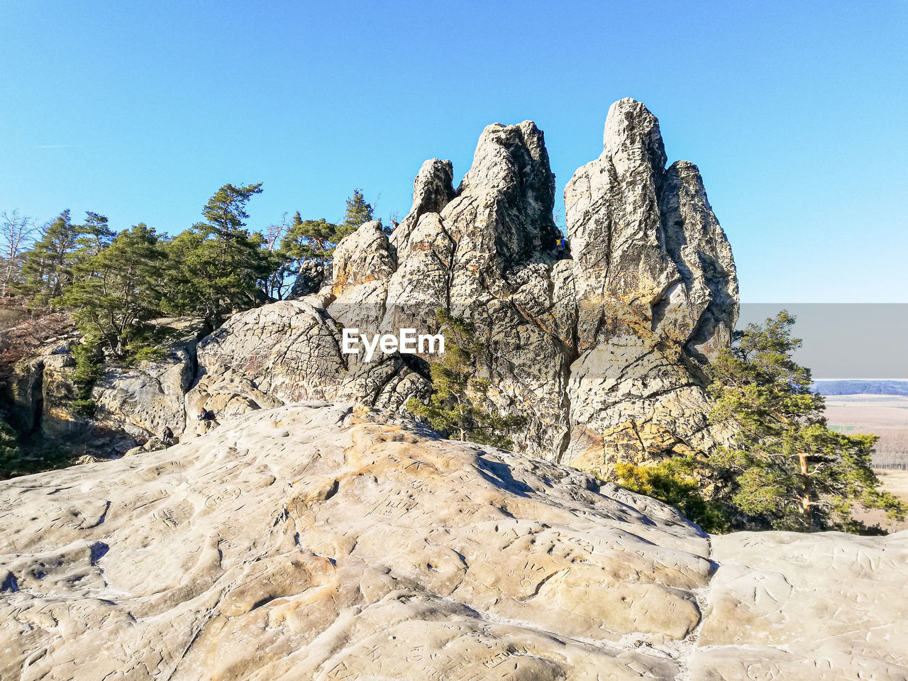 rock, sky, nature, clear sky, scenics - nature, land, mountain, beauty in nature, plant, geology, tree, landscape, travel destinations, no people, rock formation, blue, day, environment, sunny, tranquility, wilderness, terrain, travel, cliff, non-urban scene, sunlight, tranquil scene, outdoors, adventure, ridge, mountain range, tourism, formation, water, sea, pinaceae