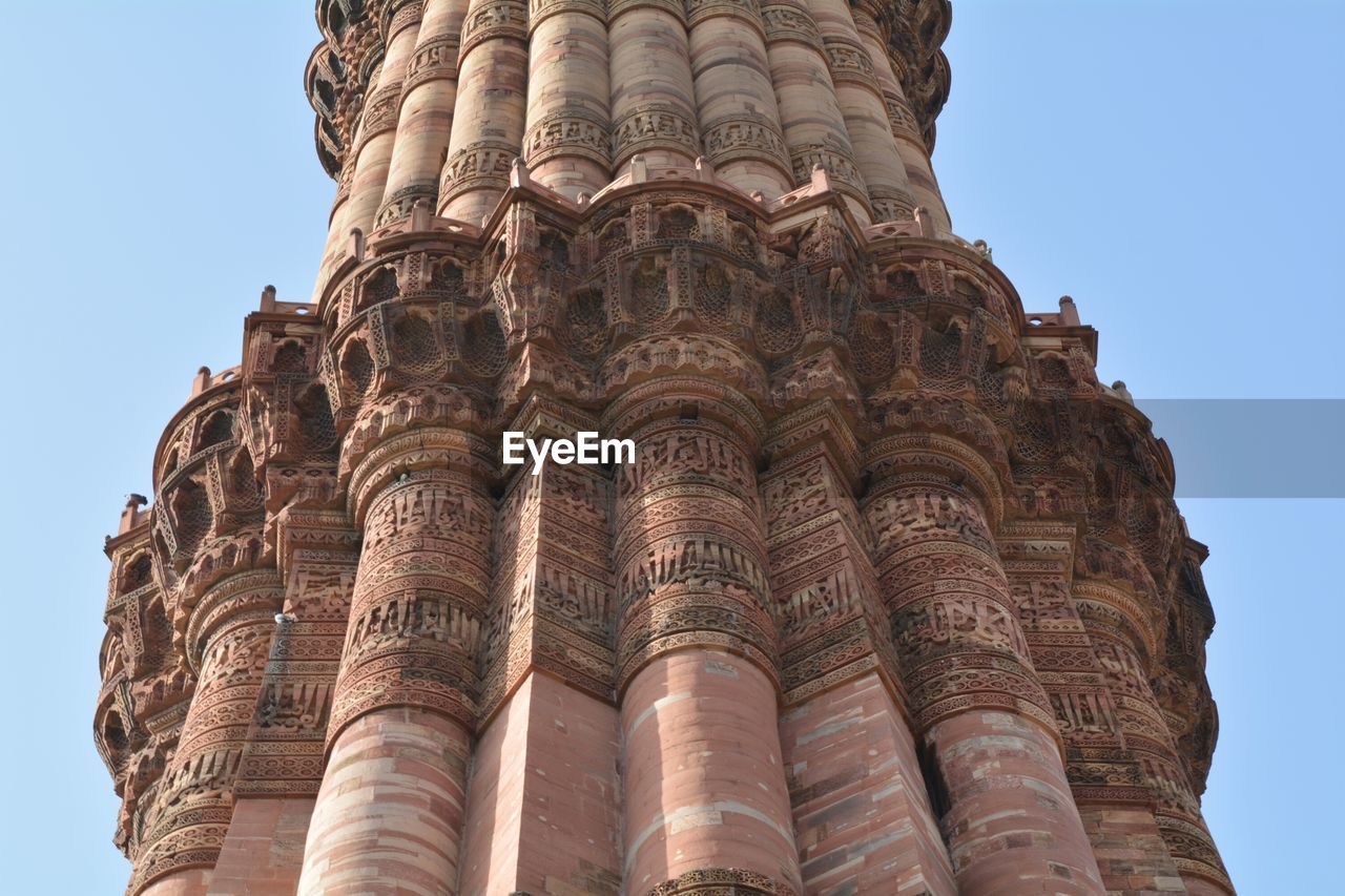 Low angle view of qutb minar against clear sky in city