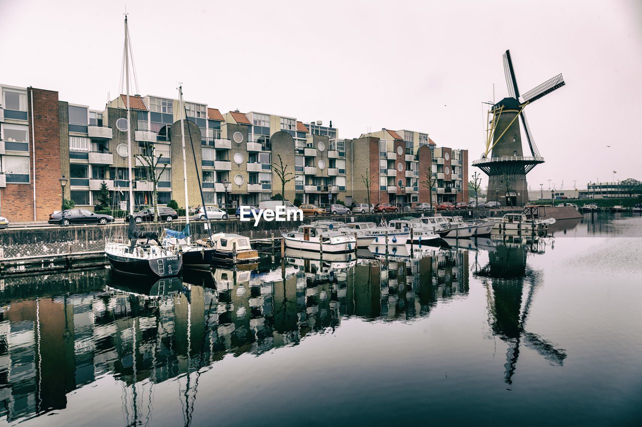 Boats moored on canal against buildings in city