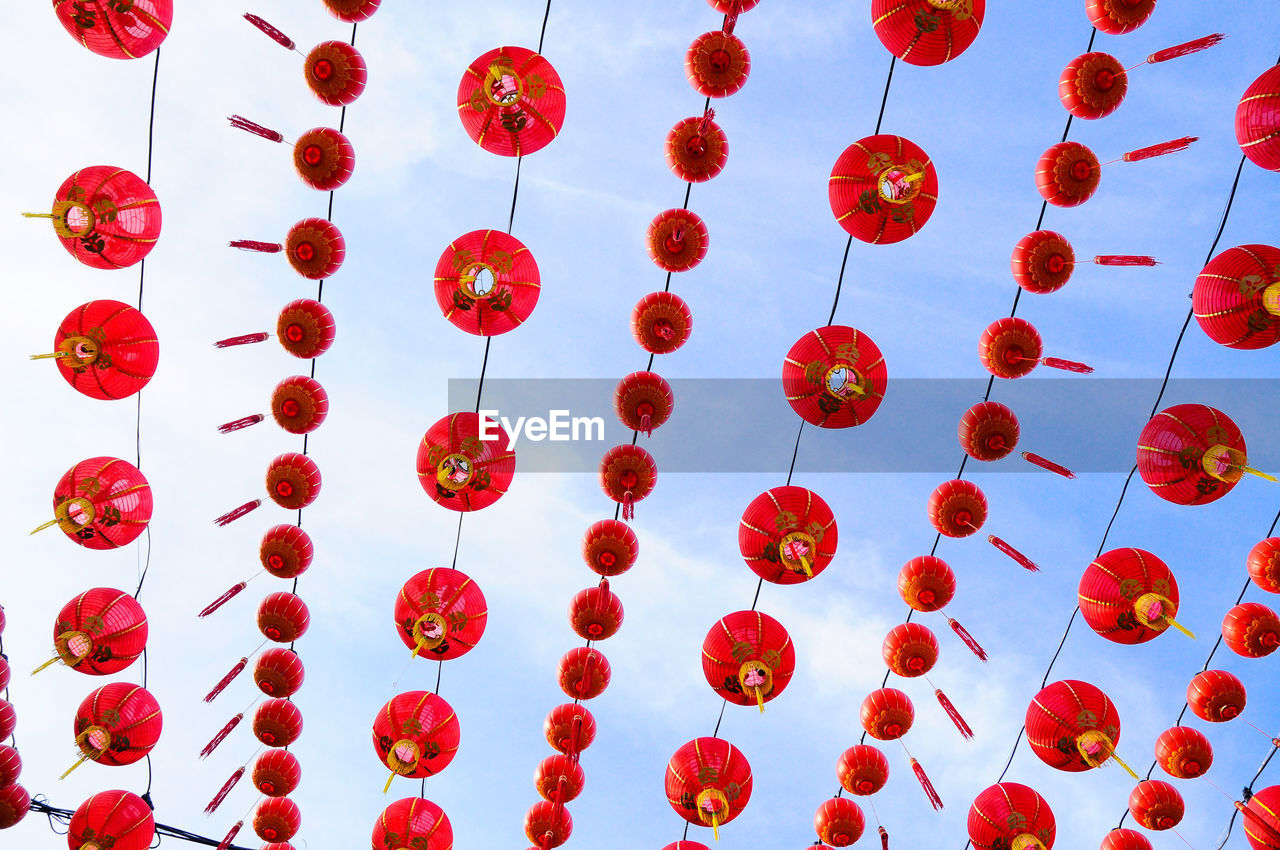 Low angle view of red lanterns hanging against sky