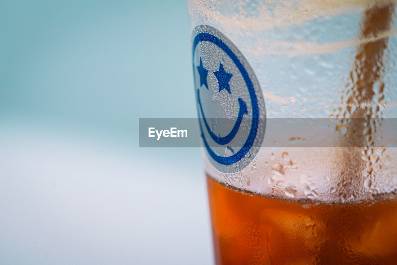 close-up of beer glass against blue background