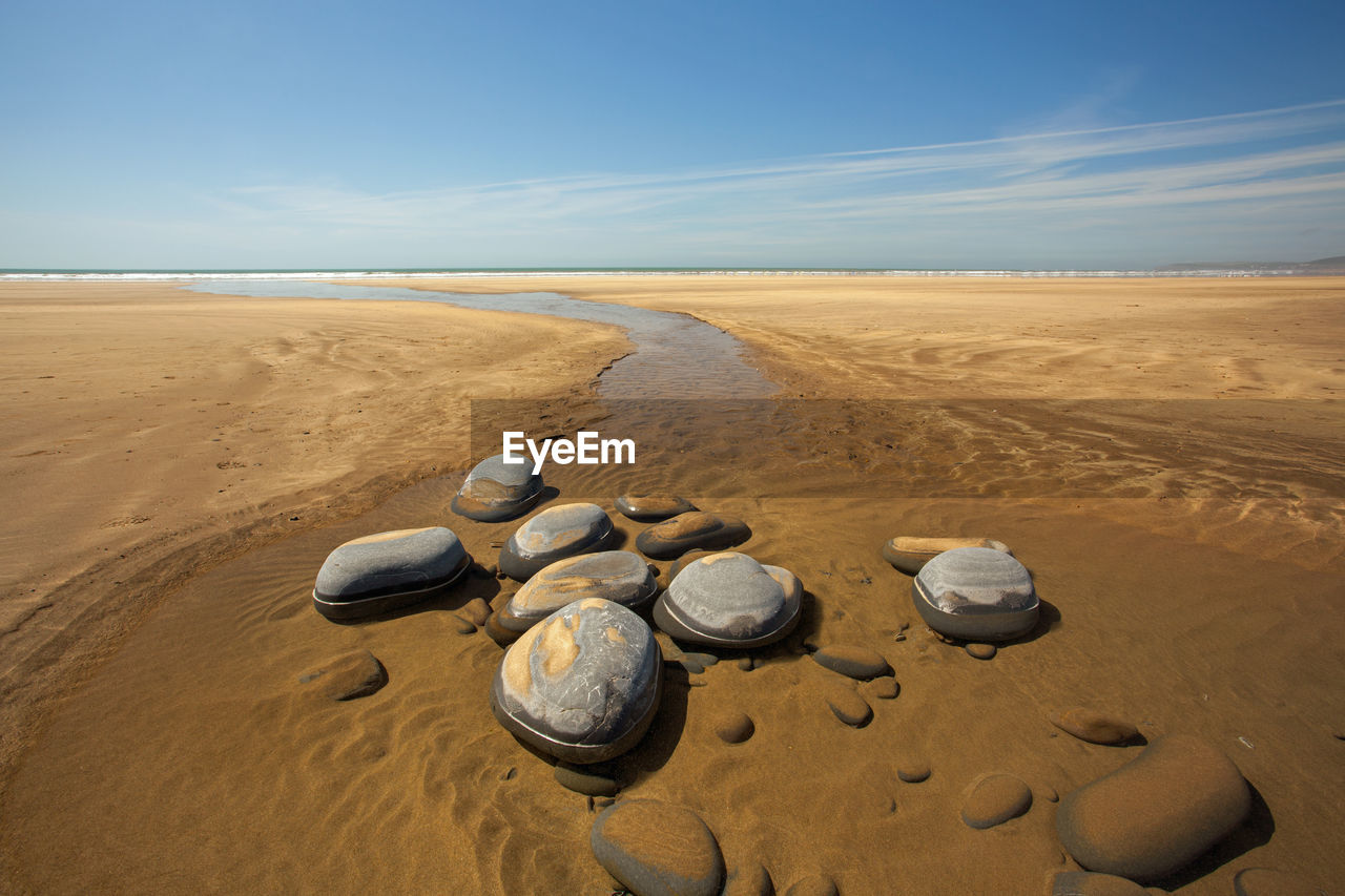 Scenic view of sand dunes at beach against sky