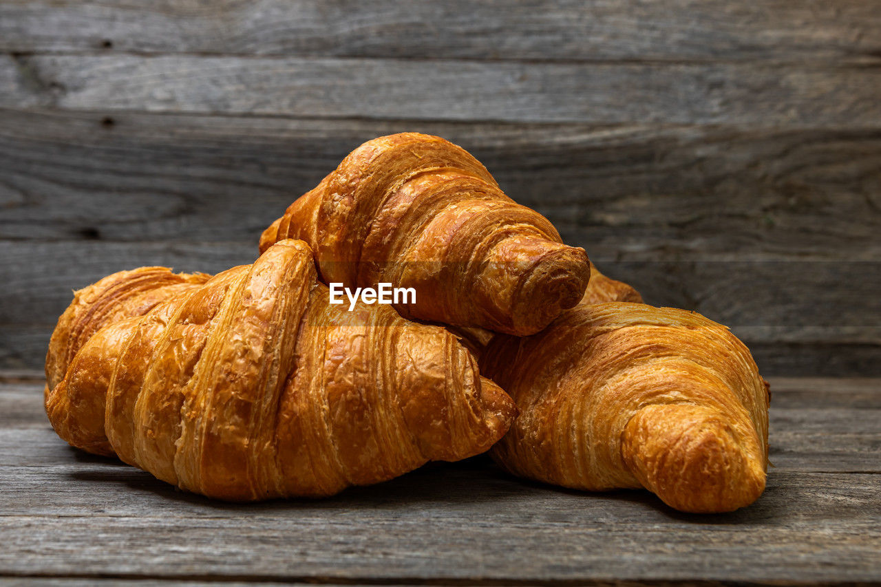 croissant, food and drink, food, french food, viennoiserie, freshness, baked, wood, table, still life, produce, no people, brown, dessert, close-up, indoors, wellbeing, healthy eating, bread, studio shot, rustic