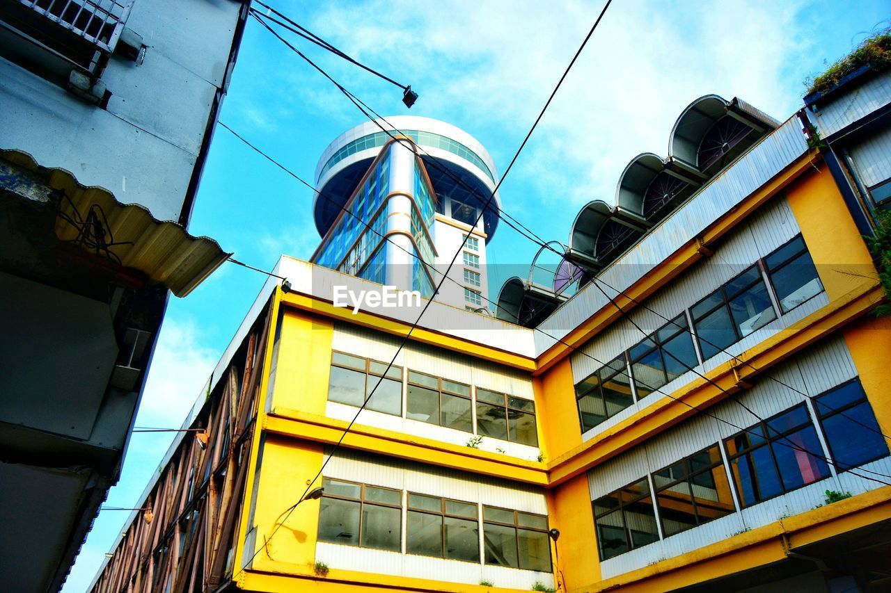 LOW ANGLE VIEW OF YELLOW BUILDINGS AGAINST SKY