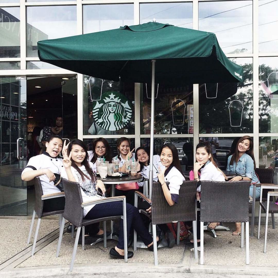 PORTRAIT OF YOUNG PEOPLE SITTING AT TABLE