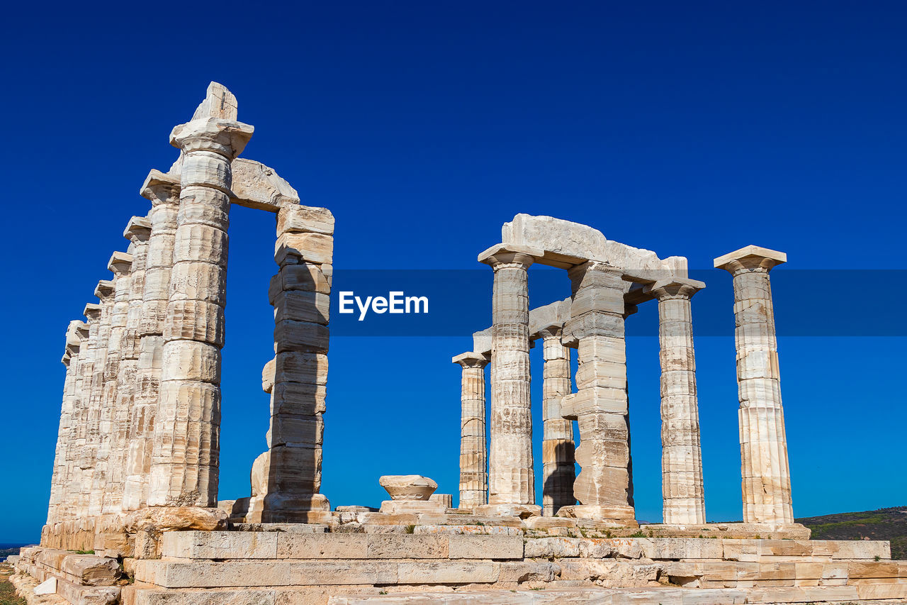 Low angle view of old ruins against blue sky