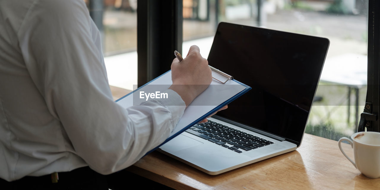 MAN USING LAPTOP ON TABLE