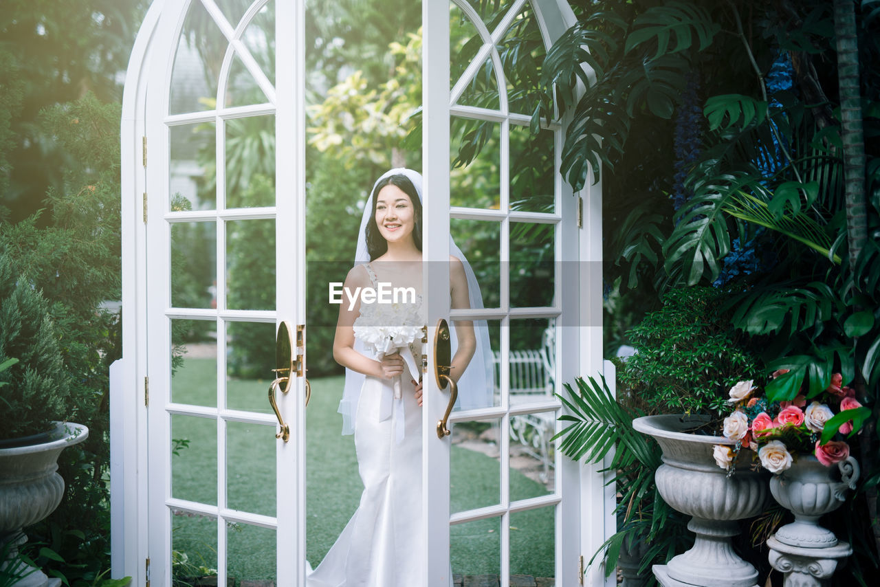 Bride standing at entrance in backyard