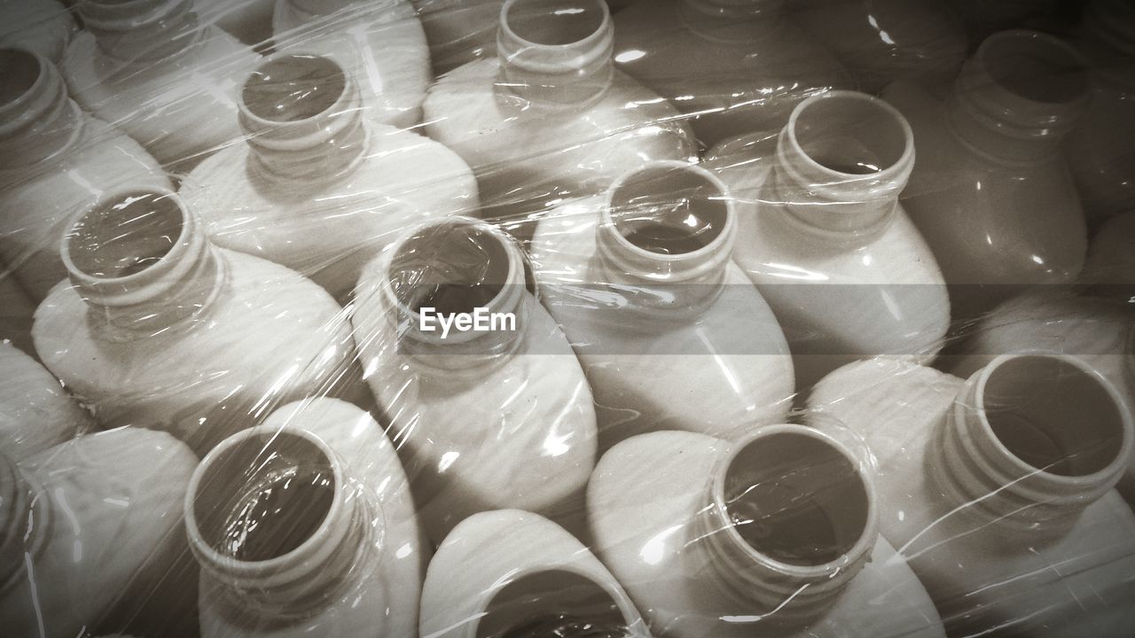 High angle view of bottles on wrapped plastic